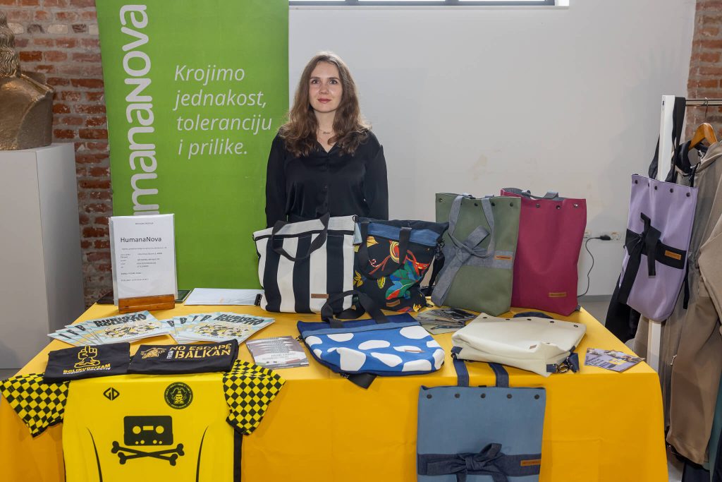 Predstavnica Humane Nove uz izlagački štand s proizvodima od prenamijenjenog tekstila i recikliranih materijala